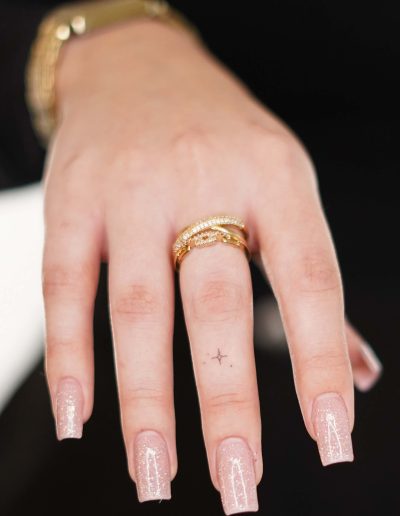 Stern-Tattoo am Mittelfinger