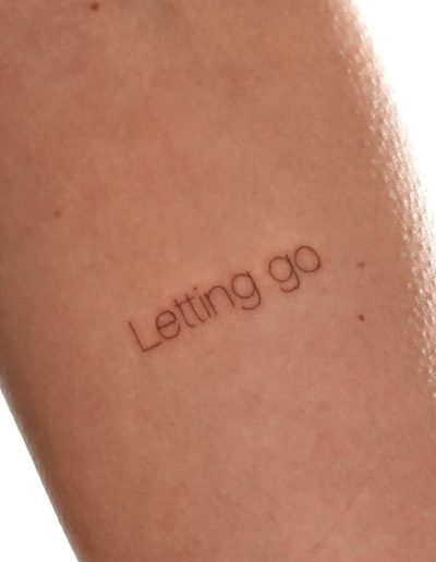 Tätowierter Schriftzug "Letting go"