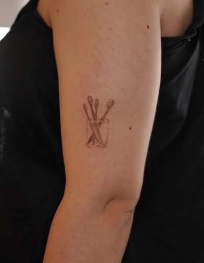 Tattoo eines Zahnputzbechers mit vier Zahnbürsten
